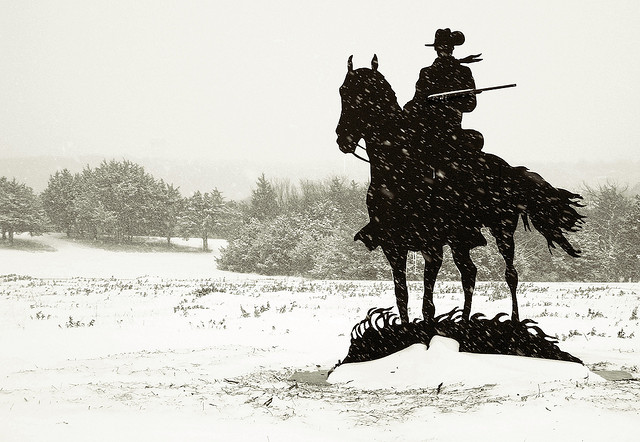 Man on horse in silhouette.
