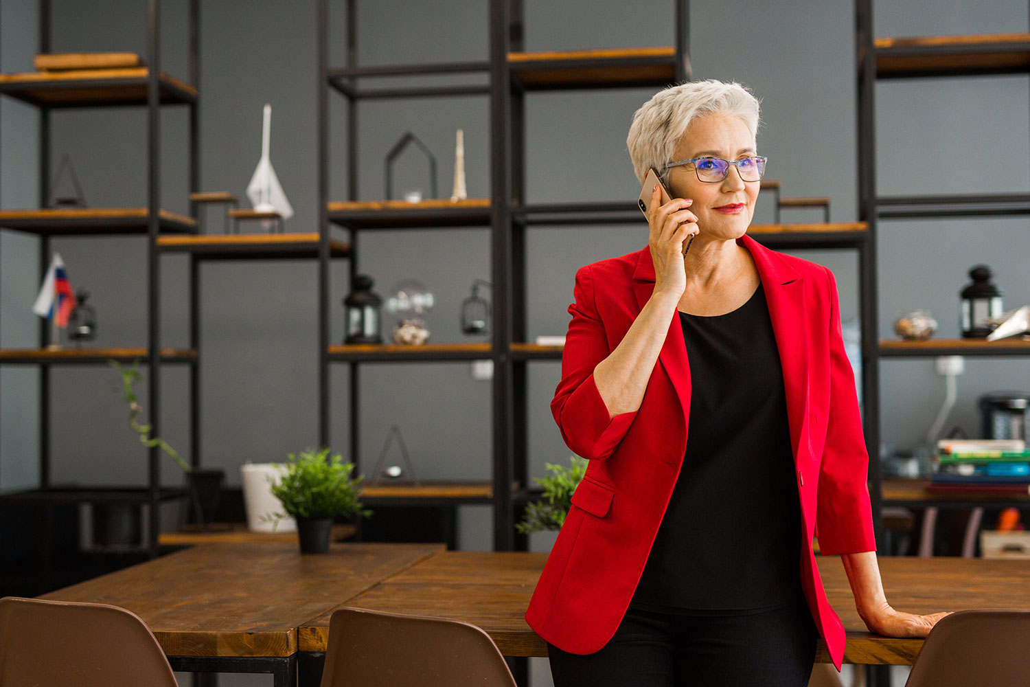 Woman in red blazer talking on cell phone.