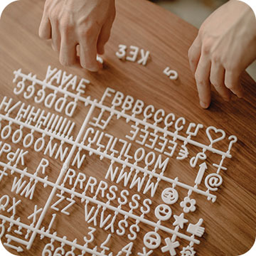 Person constructing words with plastic lettering