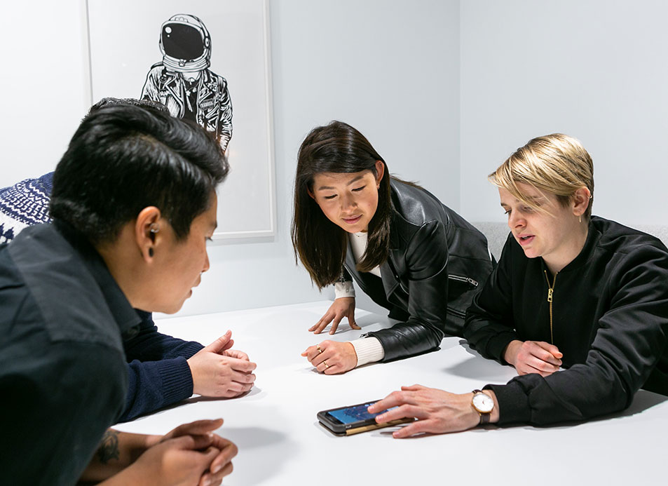 people in meeting centered around cellphone