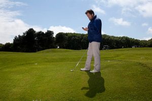 man on cellphone on golf course