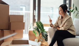 Women on phone with moving boxes